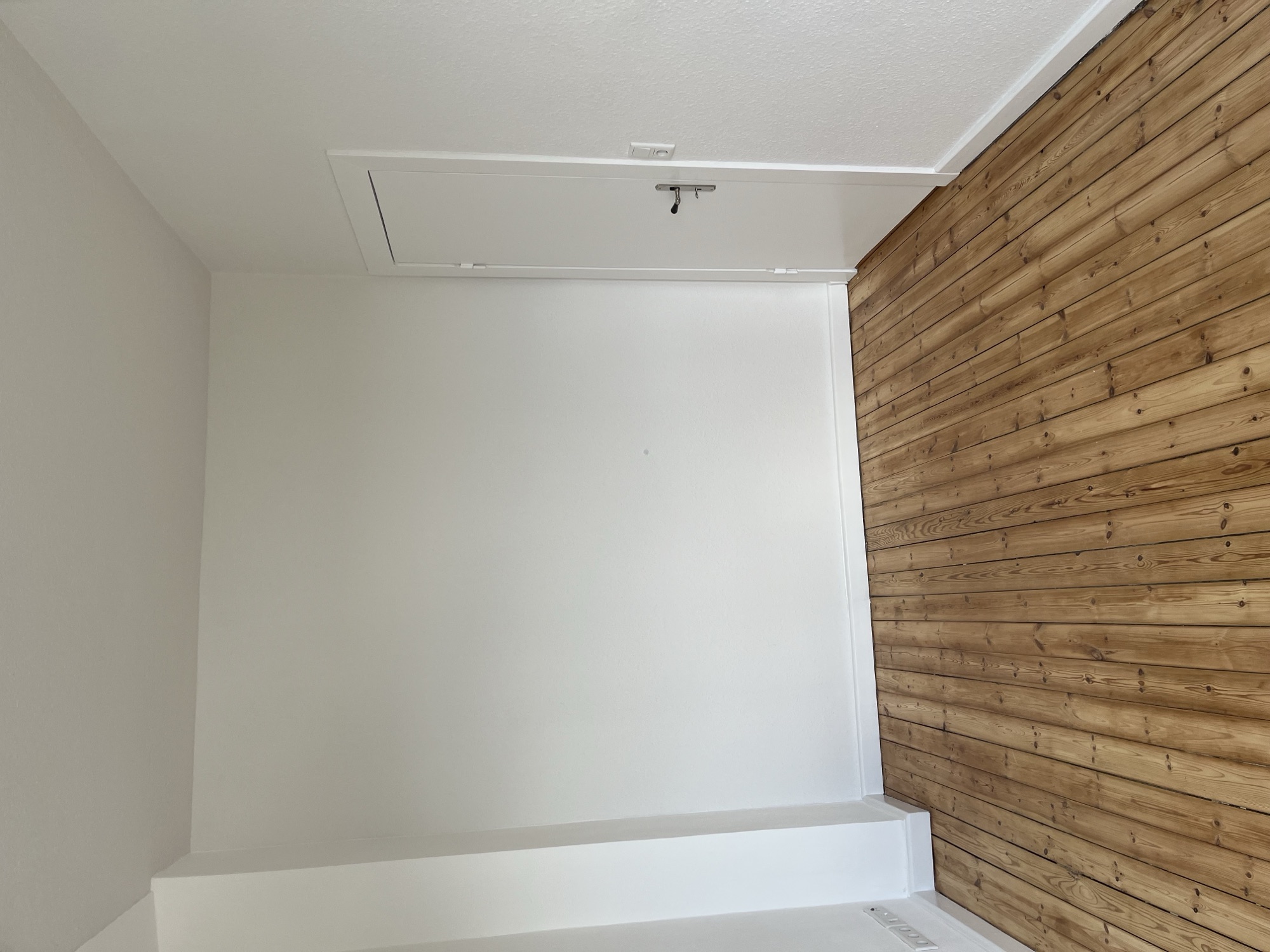 Renovierter Raum mit Holzboden und weißen Wänden