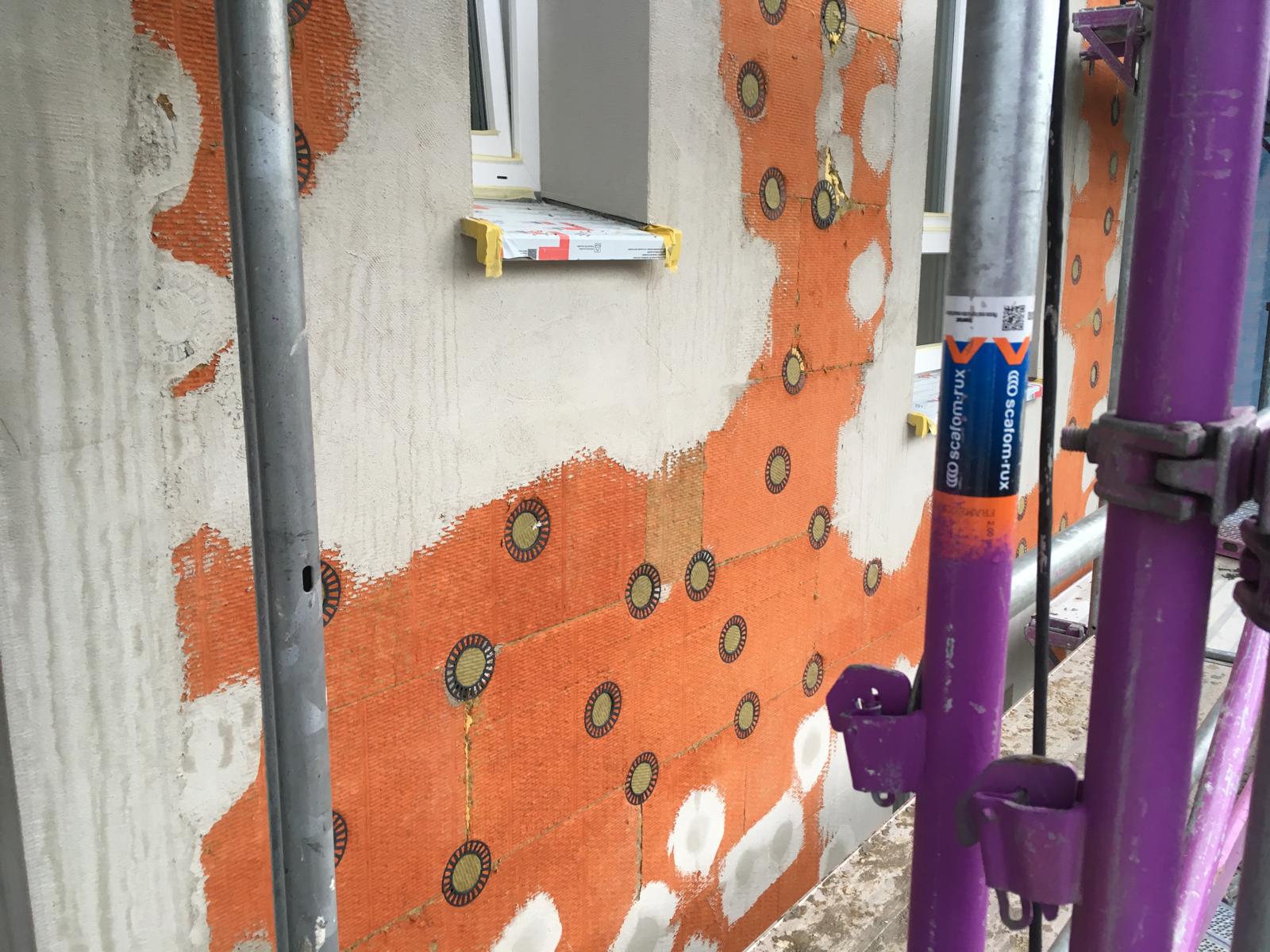 Wärmedämmung an der Fassade mit Fensterbank und Gerüst